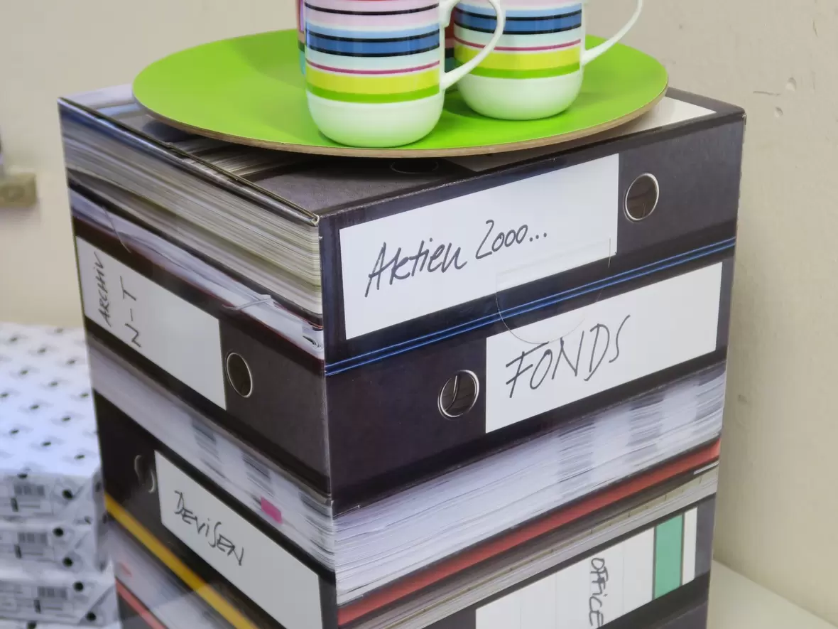 buerotechnik-weiss-e-k-neuburg-dekoration-fuer-das-buero-auf-schrank-mit-tassen-und-teller-darauf